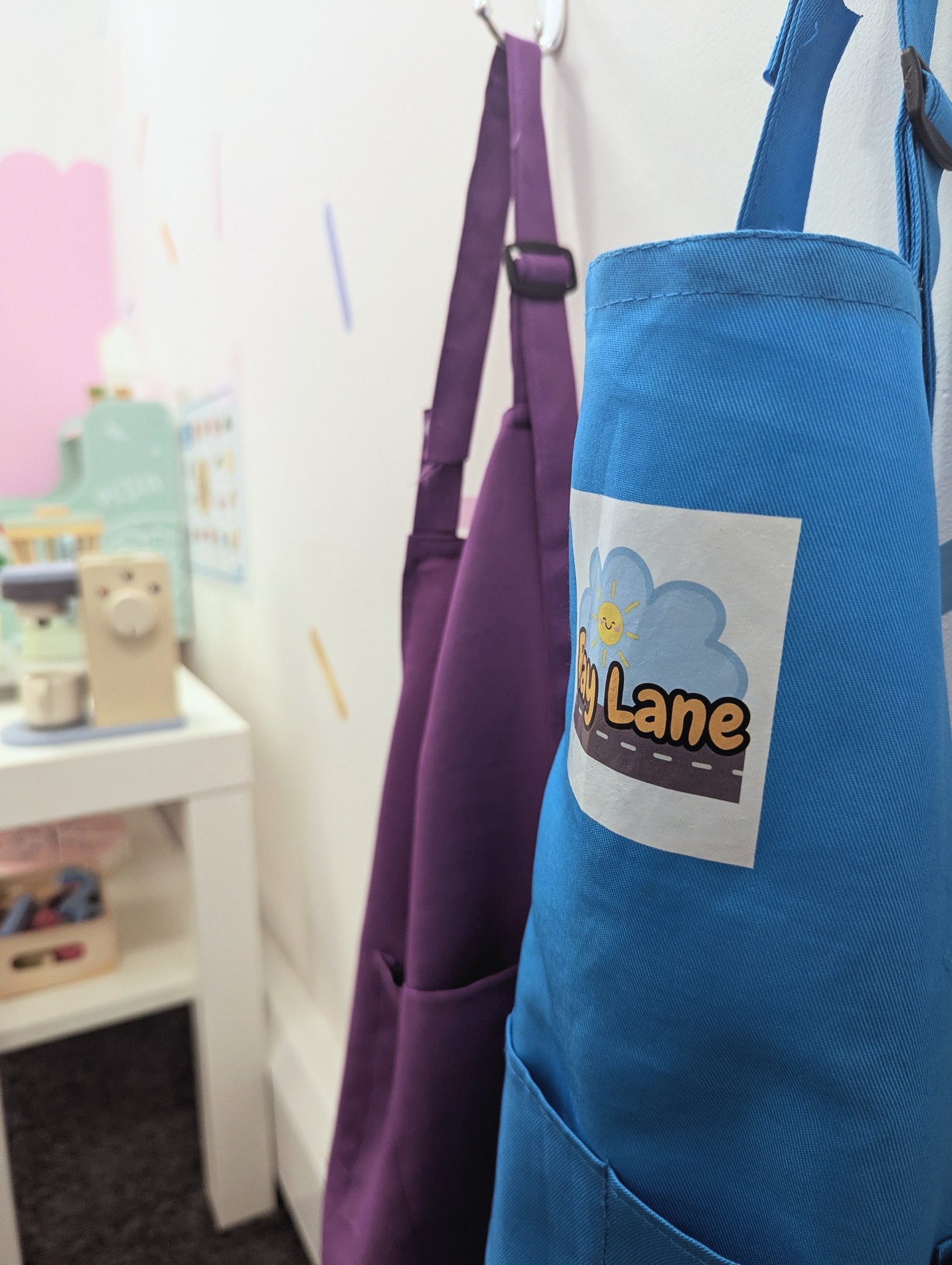 Play Lane aprons hanging by the role play kitchen